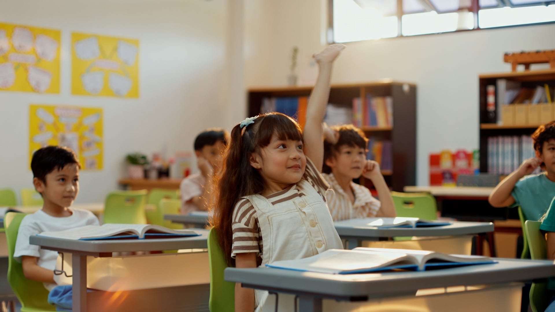 A teacher explains the new ABC song to young students, highlighting the updated phrasing for improved literacy skills.