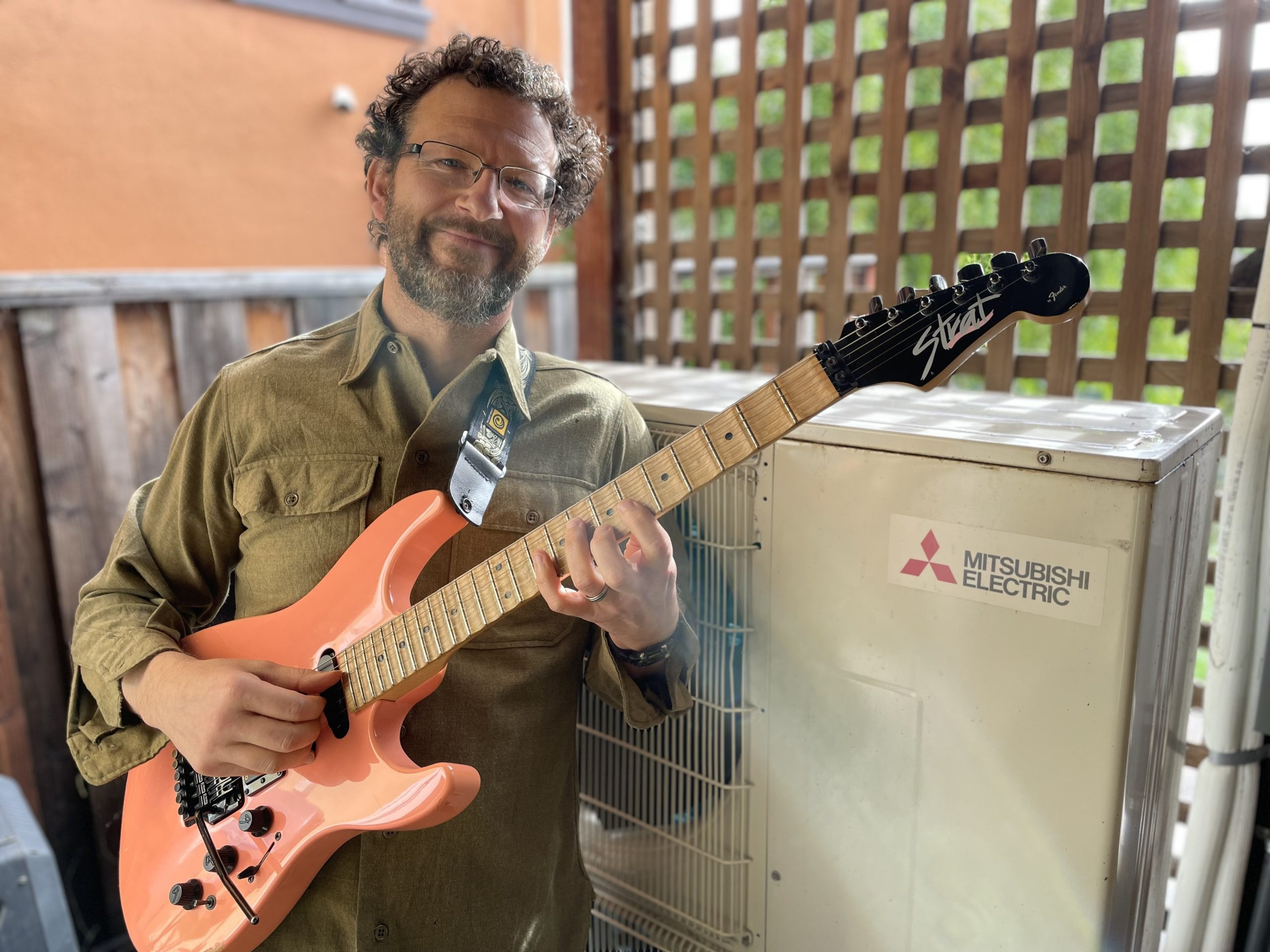 Mike Roberts and his muse, a Mitsubishi heat pump, in his North Berkeley backyard.