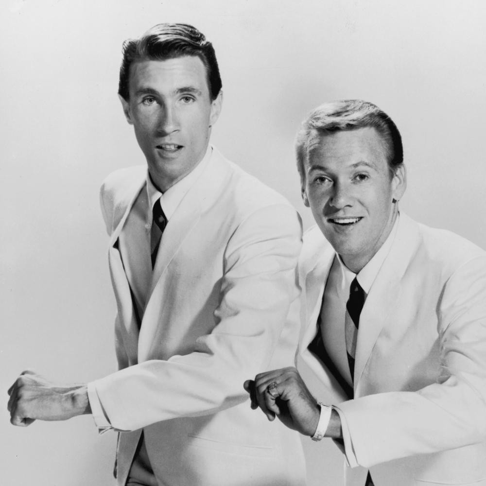 The Righteous Brothers in white suits, Bill Medley on the left and Bobby Hatfield on the right, posing for a promotional shot.